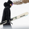 Women carrying Faction Prodigy 2 Capsule white ski in a snowy setting.
